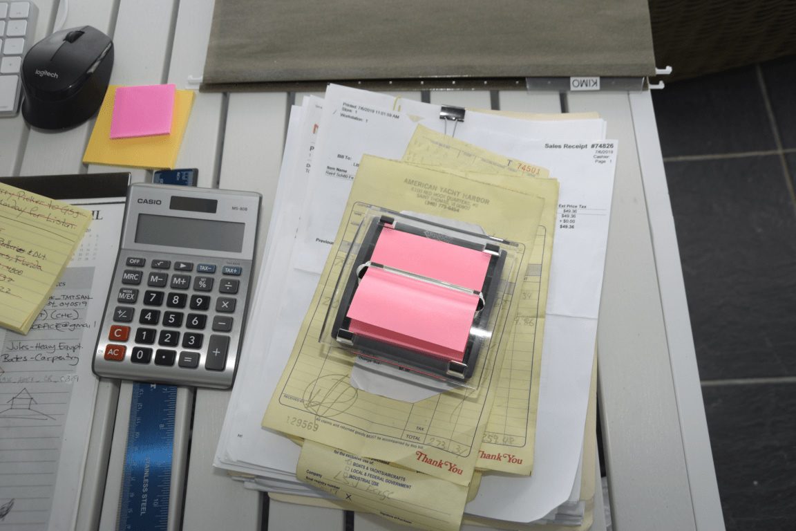 A desk with a calculator, notebook, and loose papers laid out for a planning session